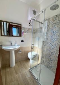 a bathroom with a shower and a sink and a toilet at Casa Del Corso in Maletto