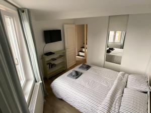 ein kleines Schlafzimmer mit einem Bett und einem Spiegel in der Unterkunft Fisherman Cottage in Yport