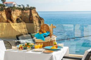 a table with food and a basket of food on it at Castelo Guest House in Carvoeiro