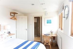 a bedroom with a bed and a desk with a laptop at Nearwater in Saint Mawes