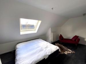 ein Schlafzimmer mit einem Bett und einem roten Stuhl in der Unterkunft No Tempo in Knesselare