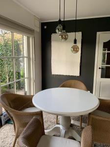 een eetkamer met een witte tafel en stoelen bij No Tempo in Knesselare