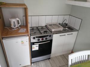 a small kitchen with a stove and a sink at Cabañas Simón y kiara in Los Vilos