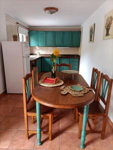 cocina con mesa de madera con sillas y nevera en Casa El Somadero A, en Fuencaliente de la Palma