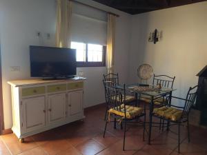 sala de estar con TV y mesa con sillas en Casa El Somadero A, en Fuencaliente de la Palma