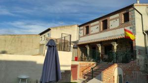 an umbrella sitting in front of a building at Casa Rural Baños de la Reina con piscina climatizada in Vega de Santa María