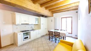 Una cocina con gabinetes blancos y una mesa con sillas. en Appartamenti San Francesco, en Lazise 25 fotos más