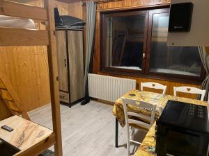 Zimmer mit einem Etagenbett, einem Tisch und Stühlen in der Unterkunft Studio Le Chitelet in La Bresse