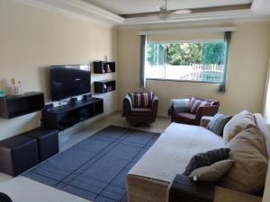 a living room with a couch and a flat screen tv at Casa em Ingleses in Florianópolis