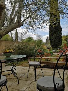 a patio with a table and two chairs and a table and a table and chairs at La Petite Seigneurette in Villeneuve-lès-Avignon