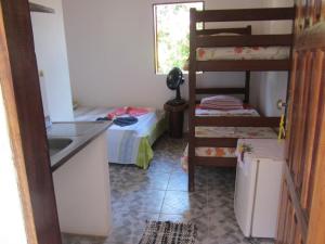 a small room with a bunk bed and a kitchen at Casa do Miguel in Itacaré