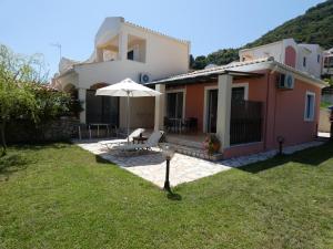 a house with an umbrella in the yard at Vivere Apartment Barbati Beach in Barbati