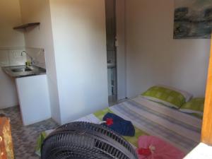 um pequeno quarto com uma cama e um lavatório em Casa do Miguel em Itacaré