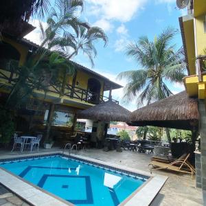 una piscina frente a una casa con palmeras en Morada do Aventureiro, en Angra dos Reis