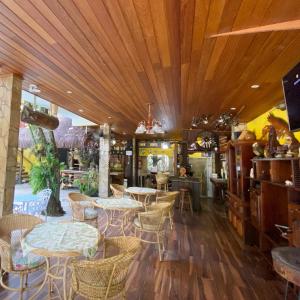 um restaurante com mesas e cadeiras num quarto em Morada do Aventureiro em Angra dos Reis