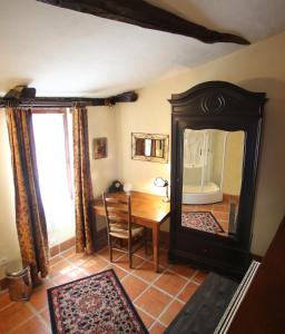 comedor con espejo y mesa en La Petite Maison, en Beynac-et-Cazenac