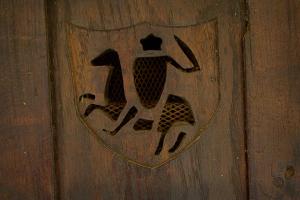 Un escudo en una puerta de madera con una persona en él. en La Petite Maison- Fairytale Stay in Village Center, en Beynac-et-Cazenac