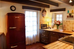 cocina con nevera y ventana en La Petite Maison, en Beynac-et-Cazenac