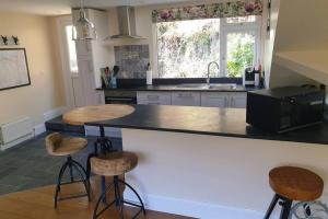 a kitchen with a counter and stools in it at The Eaves in Lynton, Exmoor, Devon in Lynton