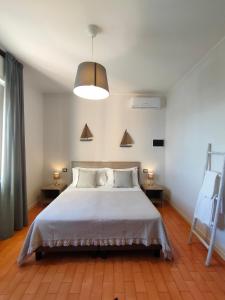 um quarto com uma cama e duas mesas e um candeeiro em Albergo La Pescatrice em Moniga