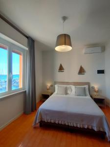 a bedroom with a large bed and a large window at Albergo La Pescatrice in Moniga