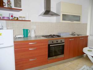 cocina con armarios de madera y horno con fogones en Apartment in Rijeka 36068 en Rijeka
