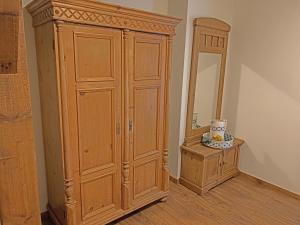 um armário de madeira num quarto ao lado de um espelho em Christinahoeve Oude Deel #1 em Boskoop
