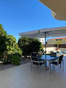 una mesa y sillas con una sombrilla en el patio en EPISKOPI VILLA, Luxury 4 Bedroom with Pool - Limassol, en Limassol