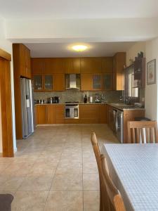a large kitchen with wooden cabinets and a table with a table sidx sidx at EPISKOPI VILLA, Luxury 4 Bedroom with Pool - Limassol in Limassol
