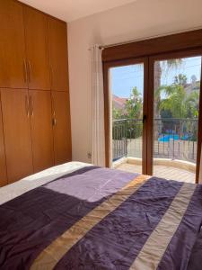 a bedroom with a bed and a large window at EPISKOPI VILLA, Luxury 4 Bedroom with Pool - Limassol in Limassol