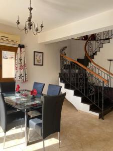 a dining room with a glass table and a staircase at EPISKOPI VILLA, Luxury 4 Bedroom with Pool - Limassol in Limassol