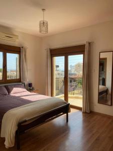 a bedroom with a bed and a view of a balcony at EPISKOPI VILLA, Luxury 4 Bedroom with Pool - Limassol in Limassol +22 photos