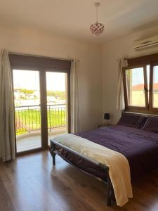a bedroom with a bed and a large window at EPISKOPI VILLA, Luxury 4 Bedroom with Pool - Limassol in Limassol