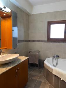 a bathroom with a sink and a tub and a bath tub at EPISKOPI VILLA, Luxury 4 Bedroom with Pool - Limassol in Limassol