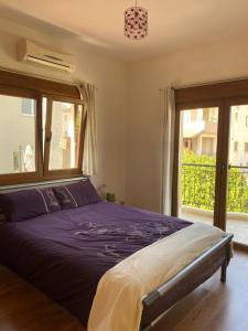 a bedroom with a purple bed and a window at EPISKOPI VILLA, Luxury 4 Bedroom with Pool - Limassol in Limassol