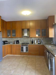a large kitchen with wooden cabinets and appliances at EPISKOPI VILLA, Luxury 4 Bedroom with Pool - Limassol in Limassol