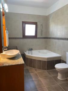 a bathroom with a tub and a toilet and a sink at EPISKOPI VILLA, Luxury 4 Bedroom with Pool - Limassol in Limassol