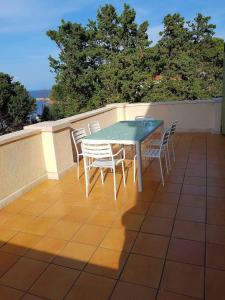 a table and chairs on top of a patio at Apartment in Veli Losinj 36588 in Veli Lošinj