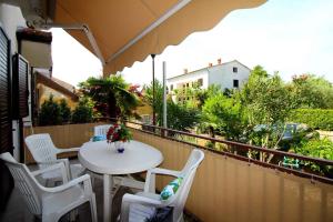 a balcony with a table and white chairs and a view at Apartment in Porec/Istrien 36682 in Poreč