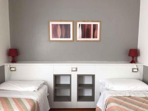 2 letti in una camera con due immagini sul muro di Apartments in Sirmione/Gardasee 22559 a Sirmione