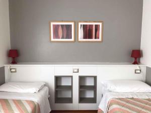 two beds in a room with two pictures on the wall at Apartments in Sirmione/Gardasee 22559 in Sirmione
