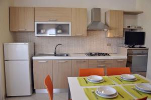 Il comprend une cuisine équipée d'une table avec des chaises et d'un réfrigérateur blanc. dans l'établissement Apartment in Lazise/Gardasee 36123, à Lazise