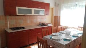 een keuken met een tafel met stoelen en een wastafel bij Holiday home in Siofok/Balaton 31176 in Siófok
