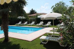 - une piscine avec des chaises longues et un parasol dans l'établissement Apartment in Lazise/Gardasee 36123, à Lazise