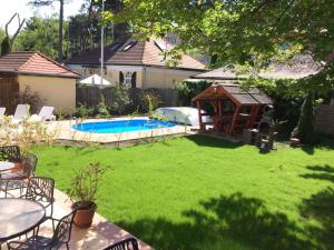 een achtertuin met een zwembad en een prieel bij Holiday home in Siofok/Balaton 31176 in Siófok