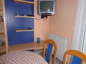 Zimmer mit einem Tisch und einem TV an der Wand in der Unterkunft Apartments in Mundanije/Insel Rab 30445 in Mundanije