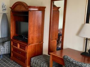 Habitación de hotel con TV en un armario de madera. en Inn at Mexia, en Mexia