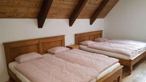 two beds in a room with wooden ceilings at Holiday home in Horni Marsov 30398 in Horní Maršov