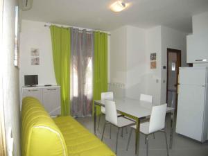 sala de estar con mesa y sofá amarillo en Apartments in Rosolina Mare 25011, en Rosolina Mare