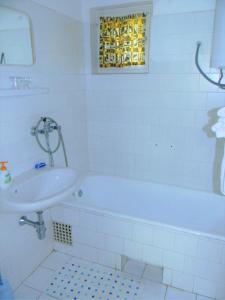 a white bathroom with a tub and a sink at Holiday home in Csopak/Balaton 18315 in Csopak